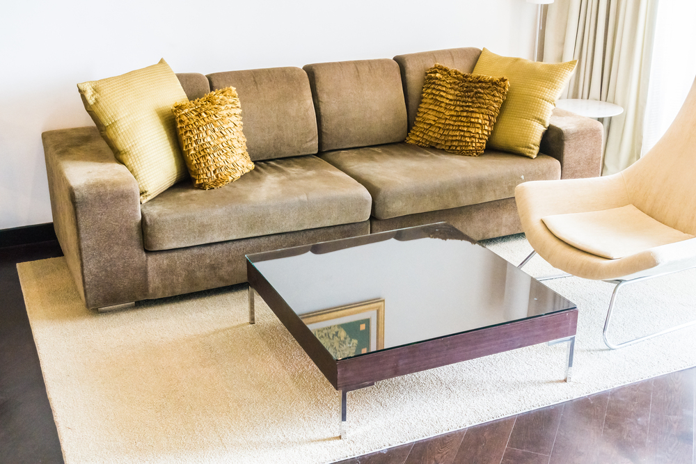 Sala decorada con mobiliario clásico y moderno, combinando tonos neutros y dorados para crear un ambiente elegante y acogedor, ideal para un enfoque funcional y personalizable en decoración.